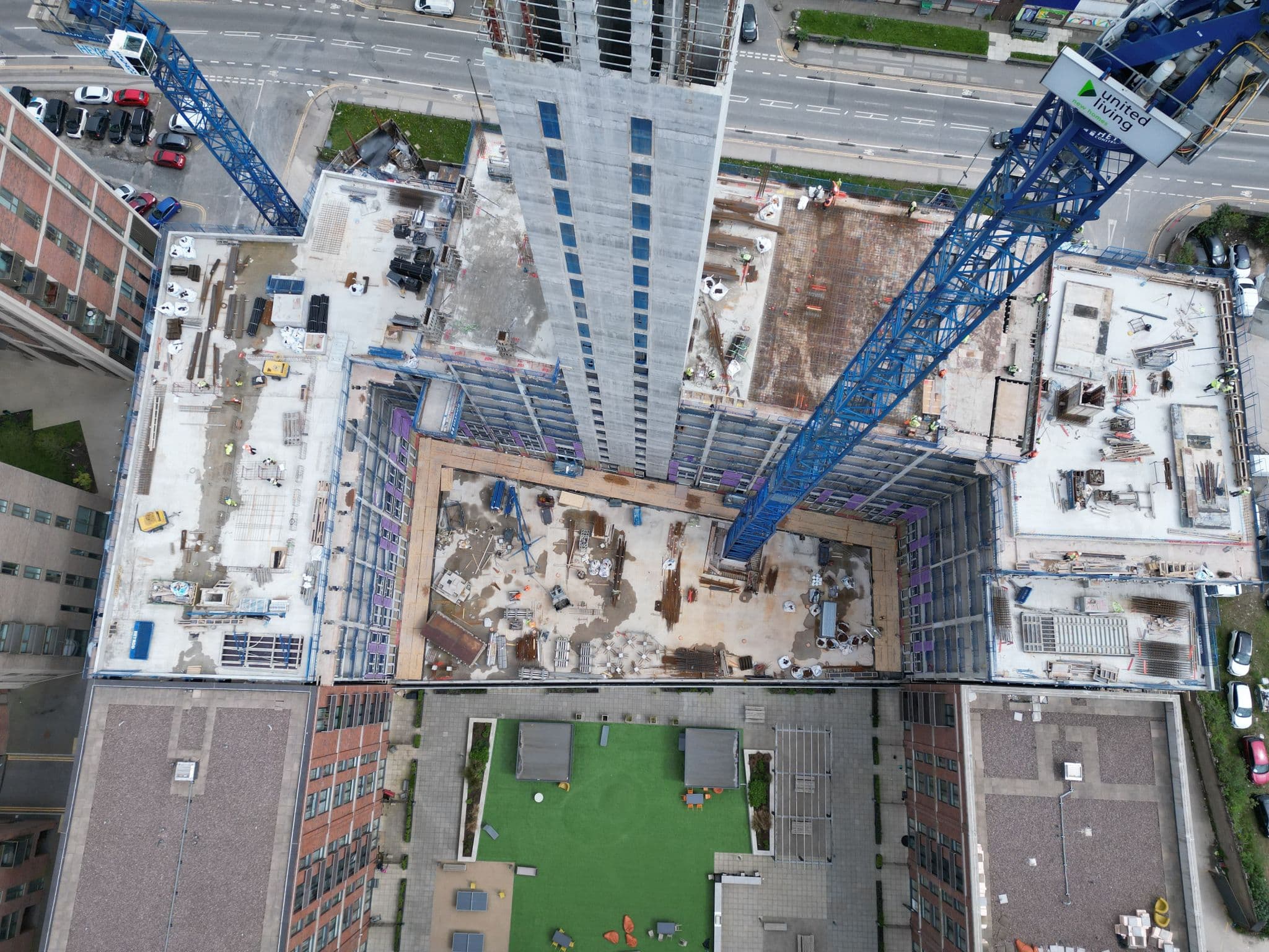 Anchor Works aerial drone view: tower crane over open floor plates mid-build, Cardiff streetscape below