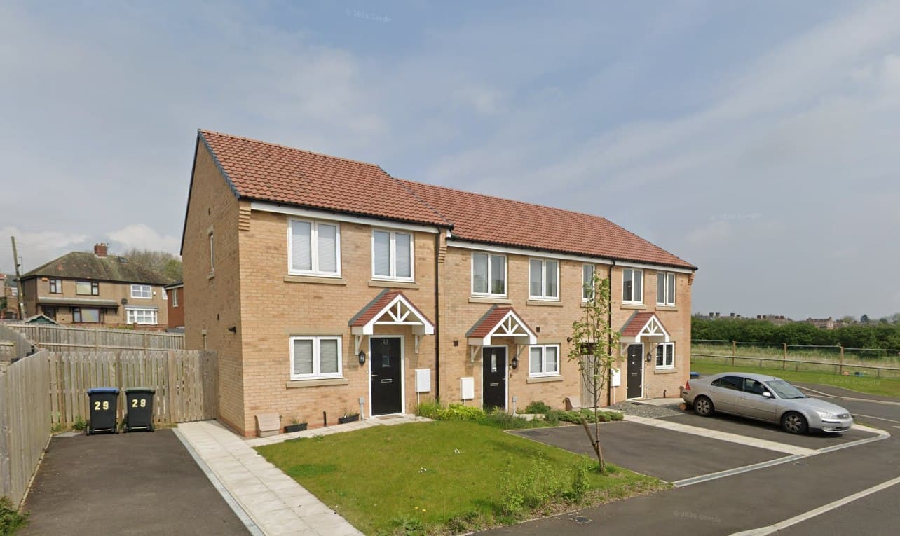 Ferryhill Dean Road, Ferryhill: buff-brick terraced homes with red-brick detailing and canopy porches, lawns to the front and open land beyond, Livin Housing affordable scheme