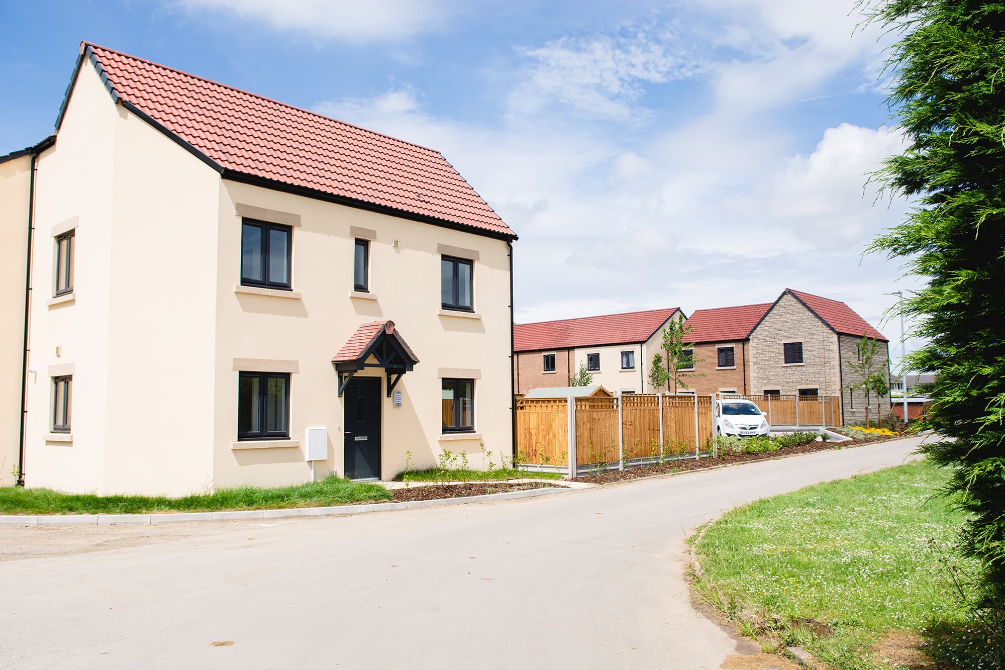 The Moorings, Pucklechurch: streetscape view of a white-rendered detached house with red-tile roof, with adjoining rendered and brick homes along the lane