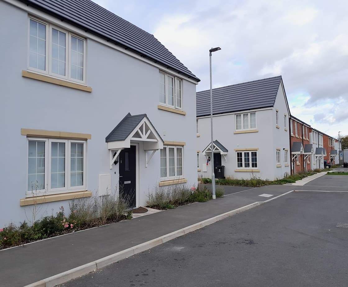 Wheater's Meadow streetscape: white-render terrace and detached homes along the new-build street
